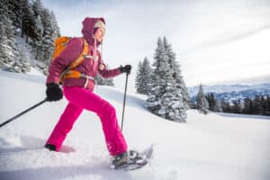 Vrouw in de sneeuw met verwarmde dameshandschoenen